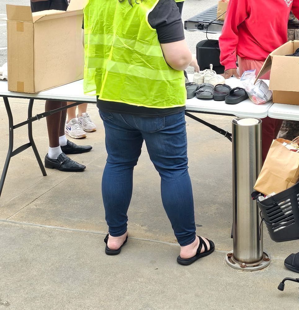 Volunteers at a table of donated shoes and clothing